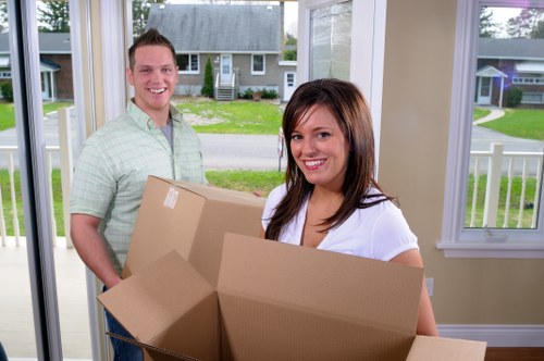 Professional movers carrying furniture carefully through a property